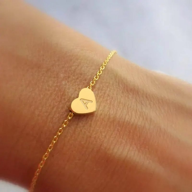 Bracelet Coeur avec Initiale <titolo_esteso><span>en acier inoxydable plaqué or jaune ou or blanc avec lettre et fermoir ajustable</span></titolo_esteso>